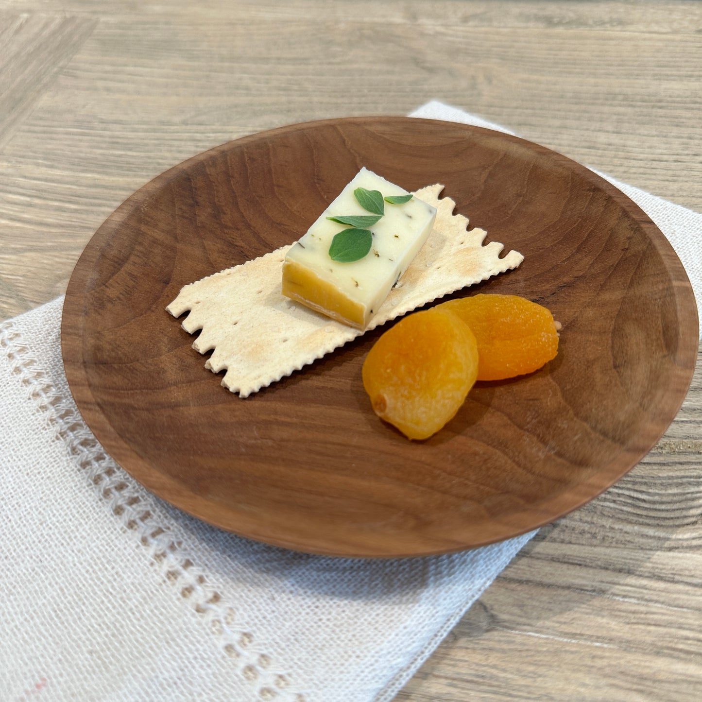 Small wood plate with cheese and cracker.