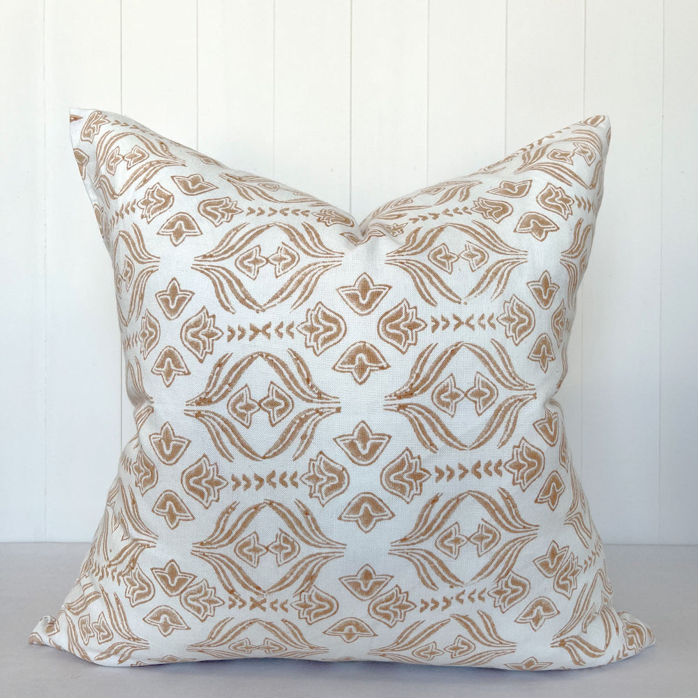 Square decorative pillow featuring hand block printing. A floral motif pattern is stamped on a white linen fabric.