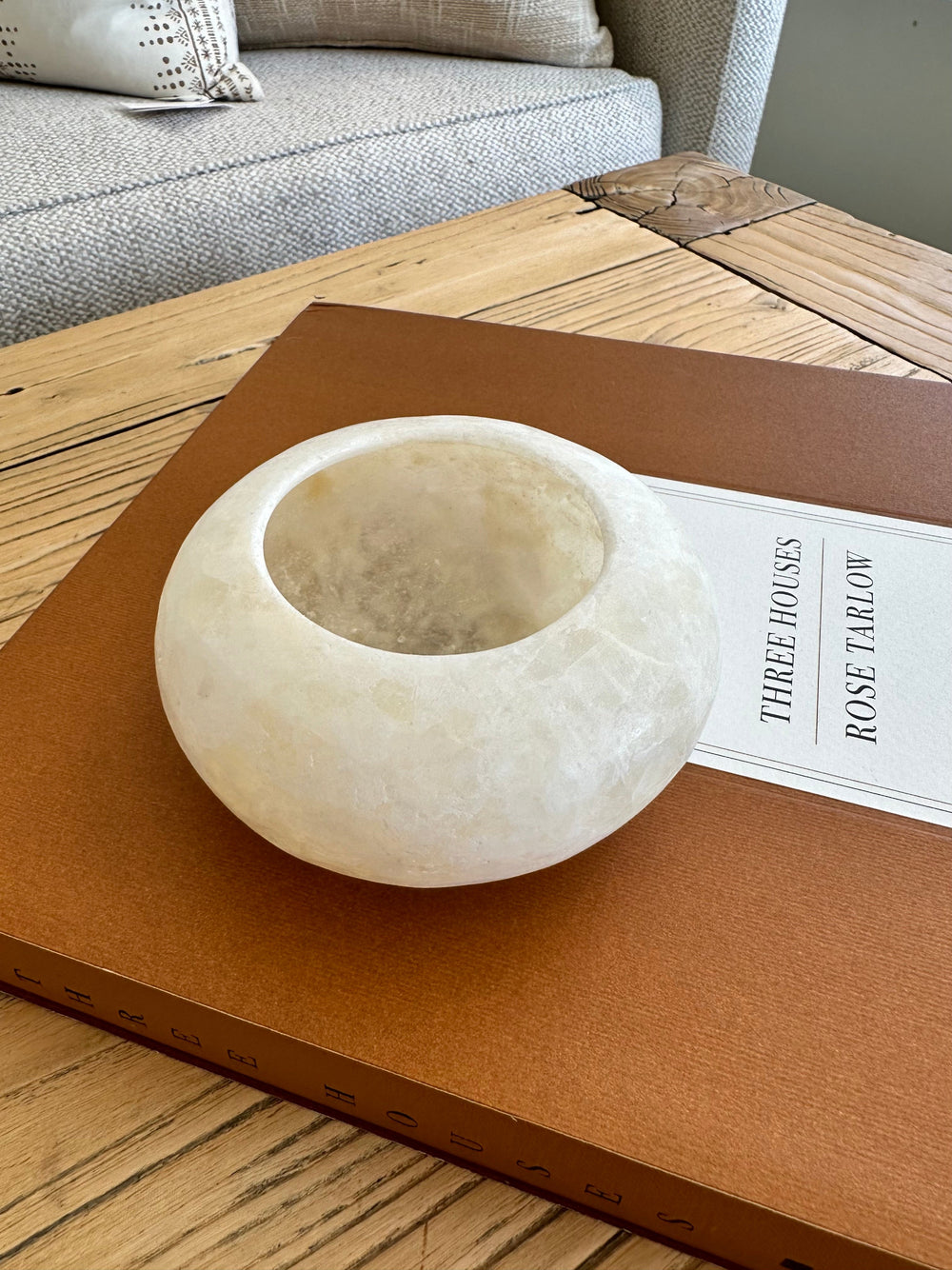 Disc Shaped Votive placed on a home decor book from above