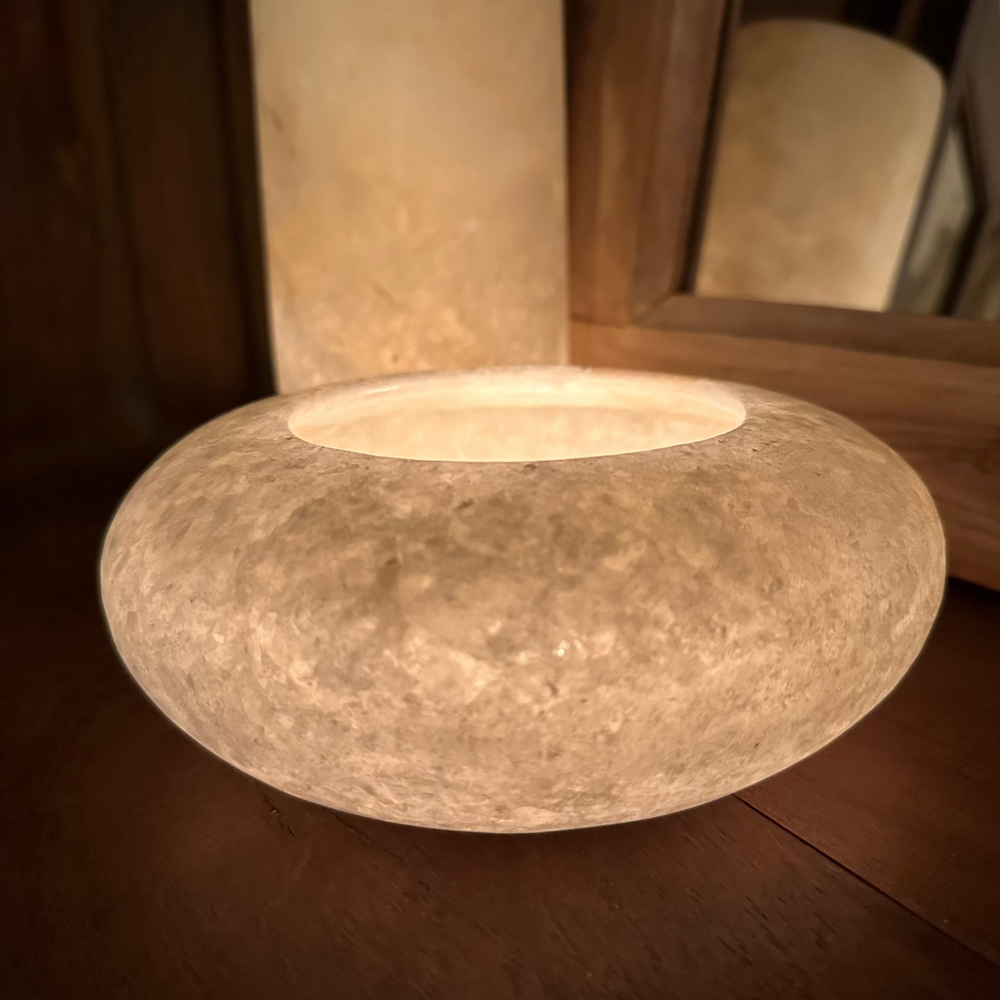 
                  
                    Alabaster Votive Disc lit with a candle looks like glowing moon
                  
                
