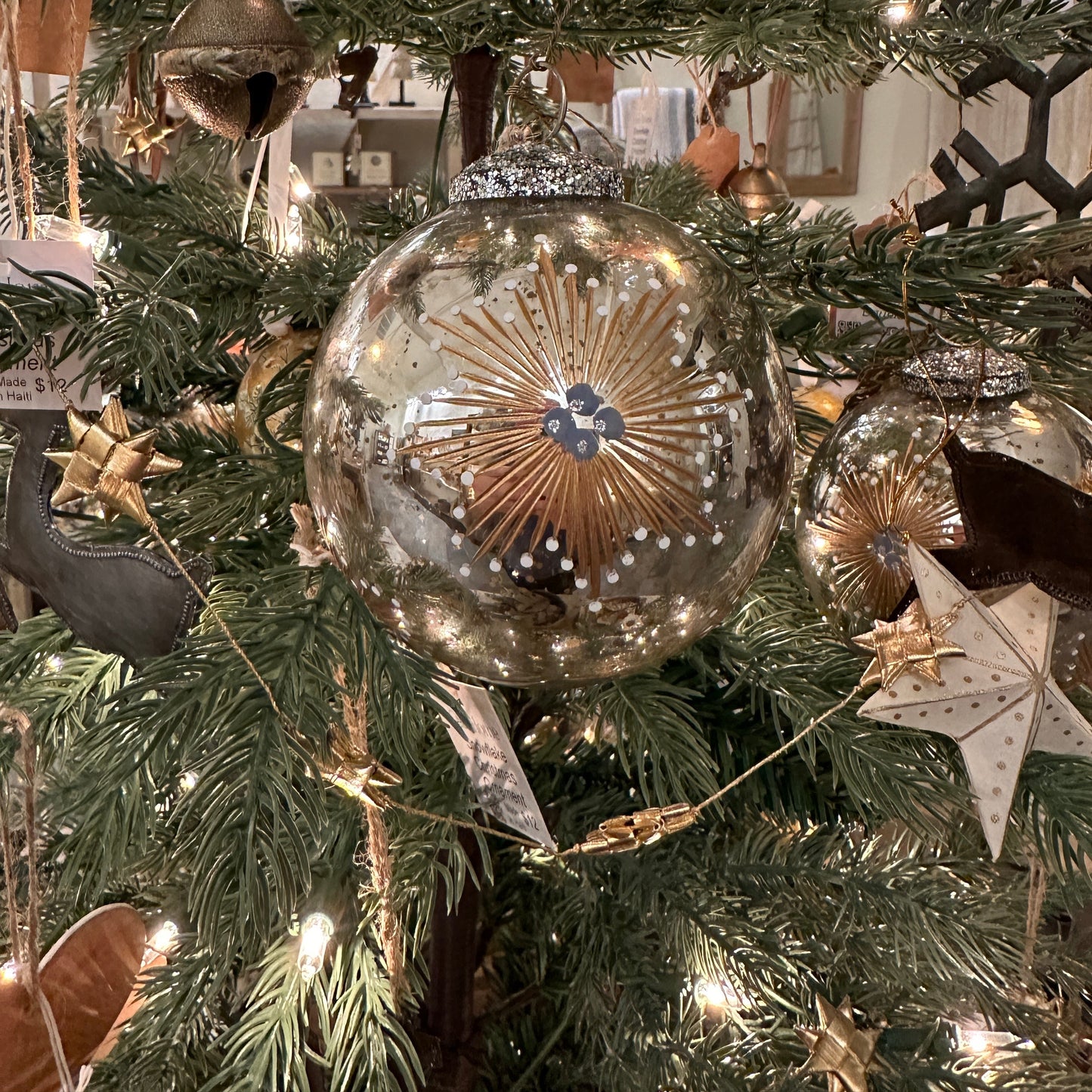 Christmas hand painted bauble hanging in a Christmas tree. Close upshot