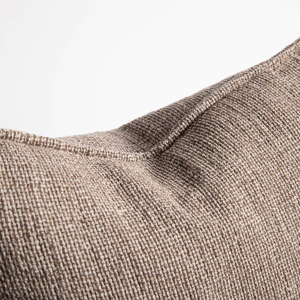 Close-up of a textured brown fabric surface with a visible seam.