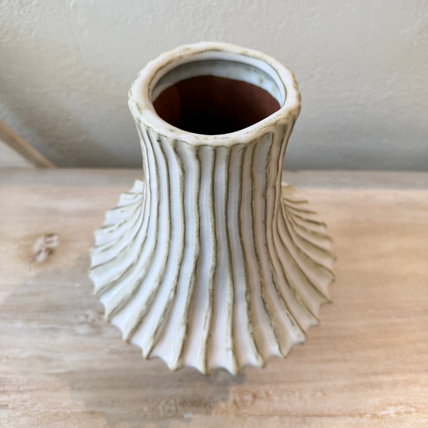 Decorative ceramic vase with textured design on a wooden surface