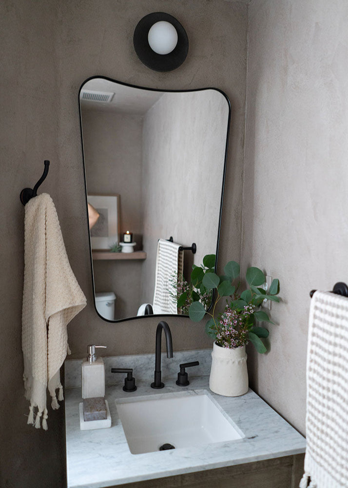Bathroom with a sink, mirror, and decorative elements.