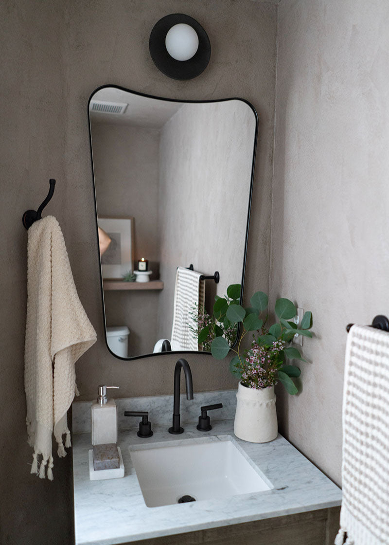 Bathroom with a sink, mirror, and decorative elements.