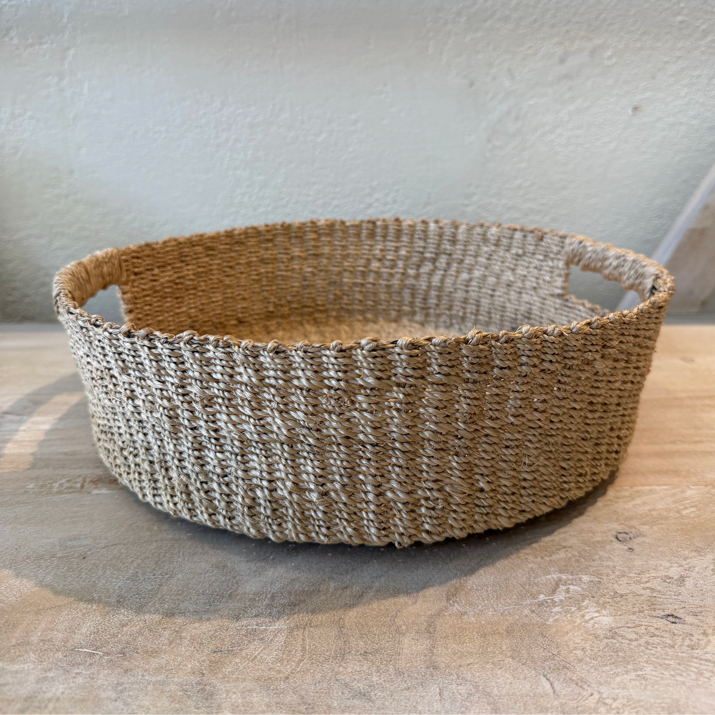 Woven basket on a wooden surface with a neutral background