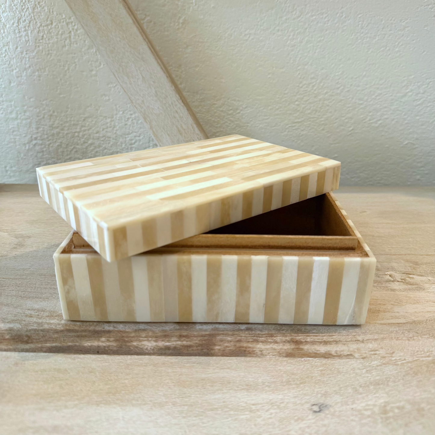 
                  
                    Wooden striped box on a wooden surface with a neutral background
                  
                