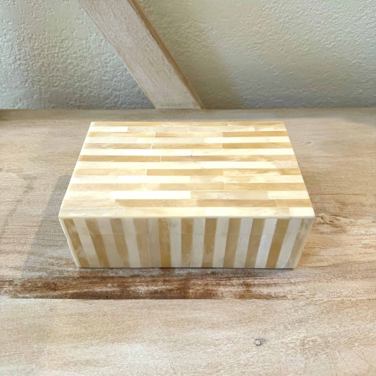 Wooden block with striped pattern on a wooden surface