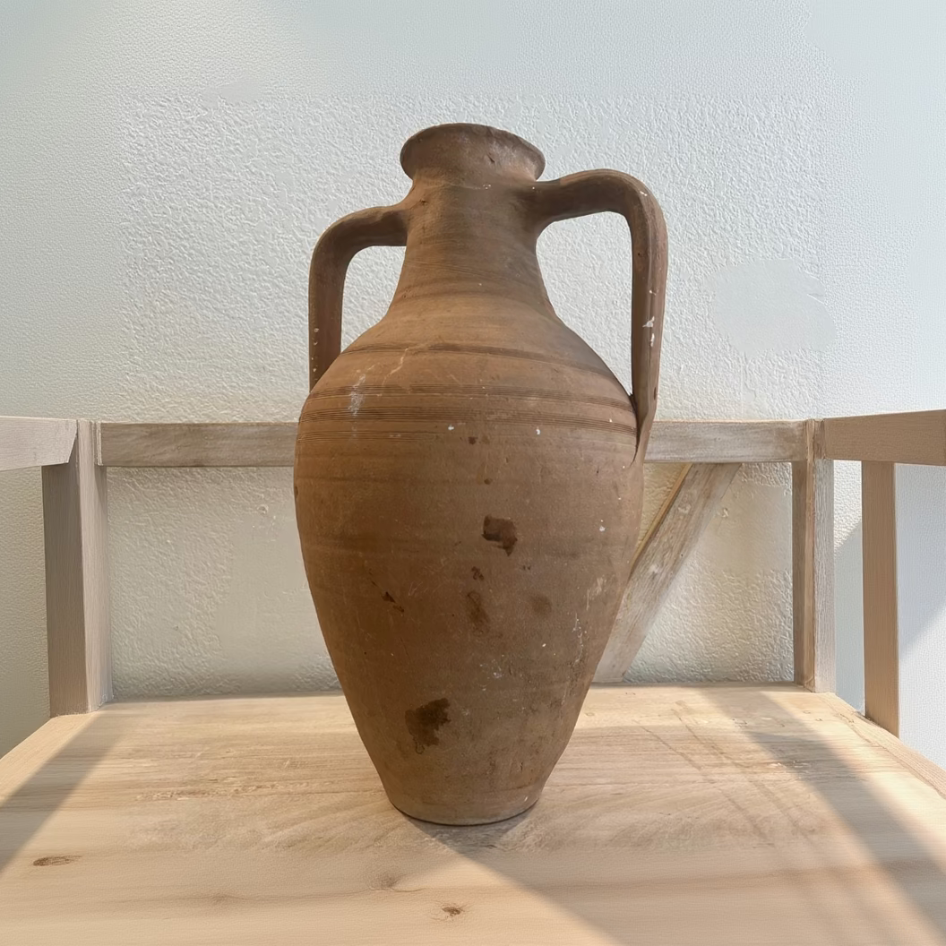 
                  
                    Brown ceramic vase with handles on a wooden surface
                  
                