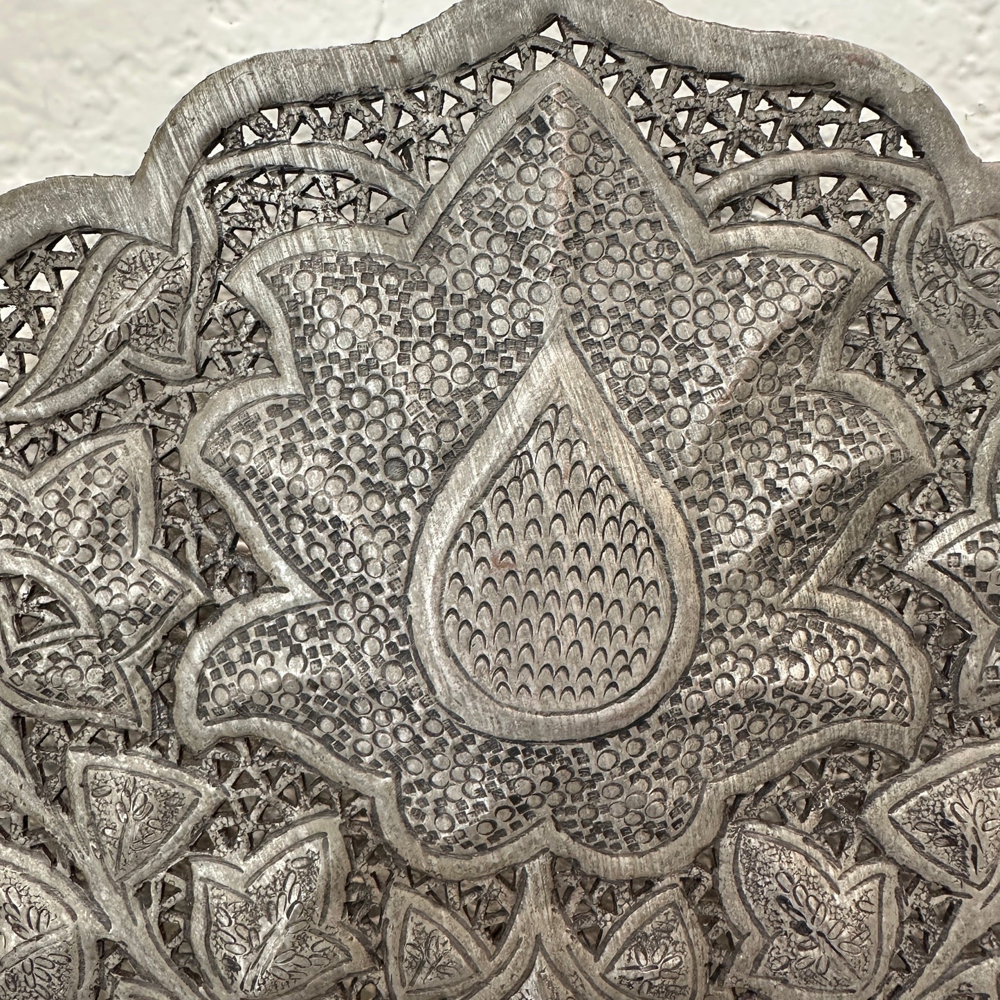 
                  
                    Detail View of a Decorative metal wall art with intricate patterns on a white wall.
                  
                