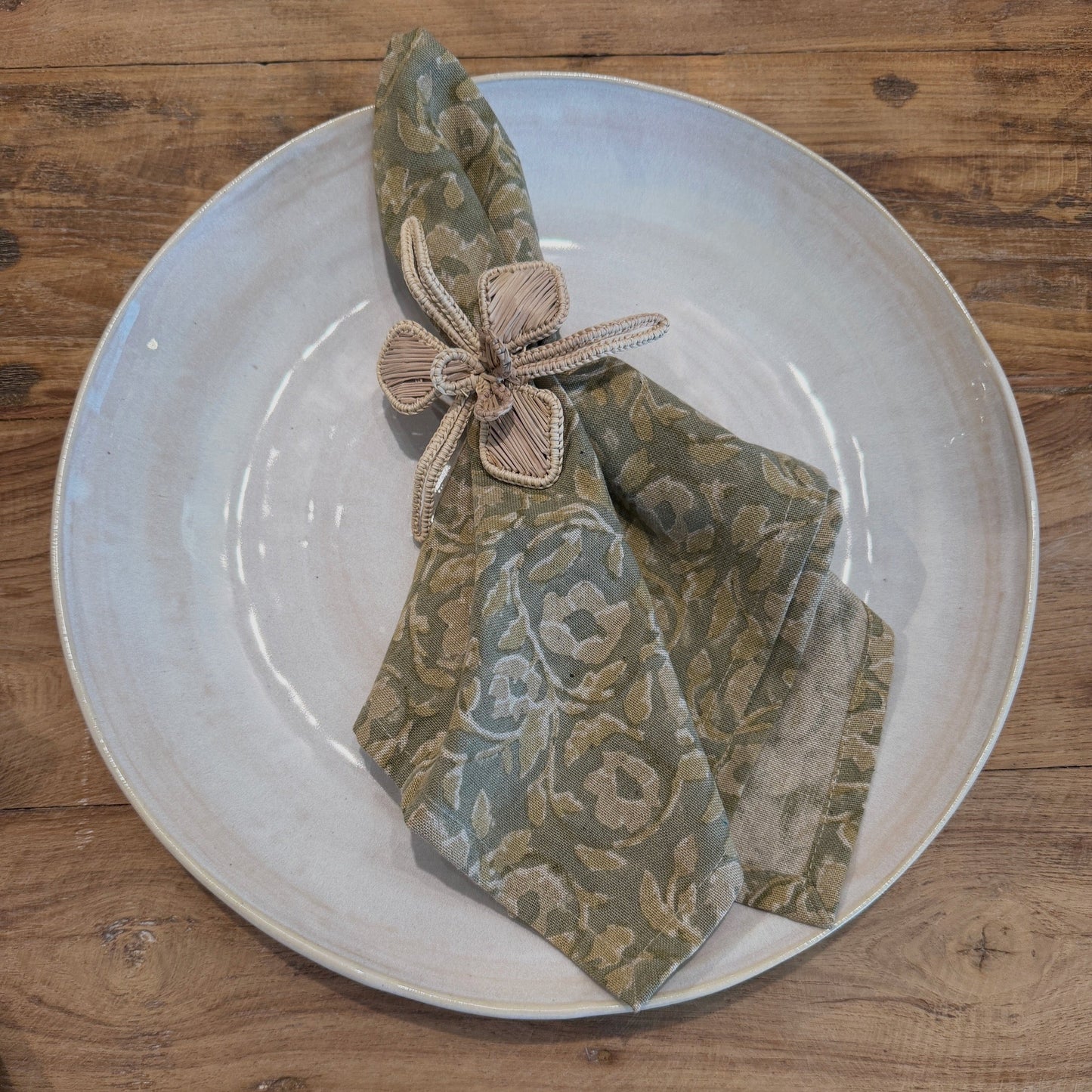 Napkin with a reed napkin holder resting on a ceramic dinner plate in the petaluma store