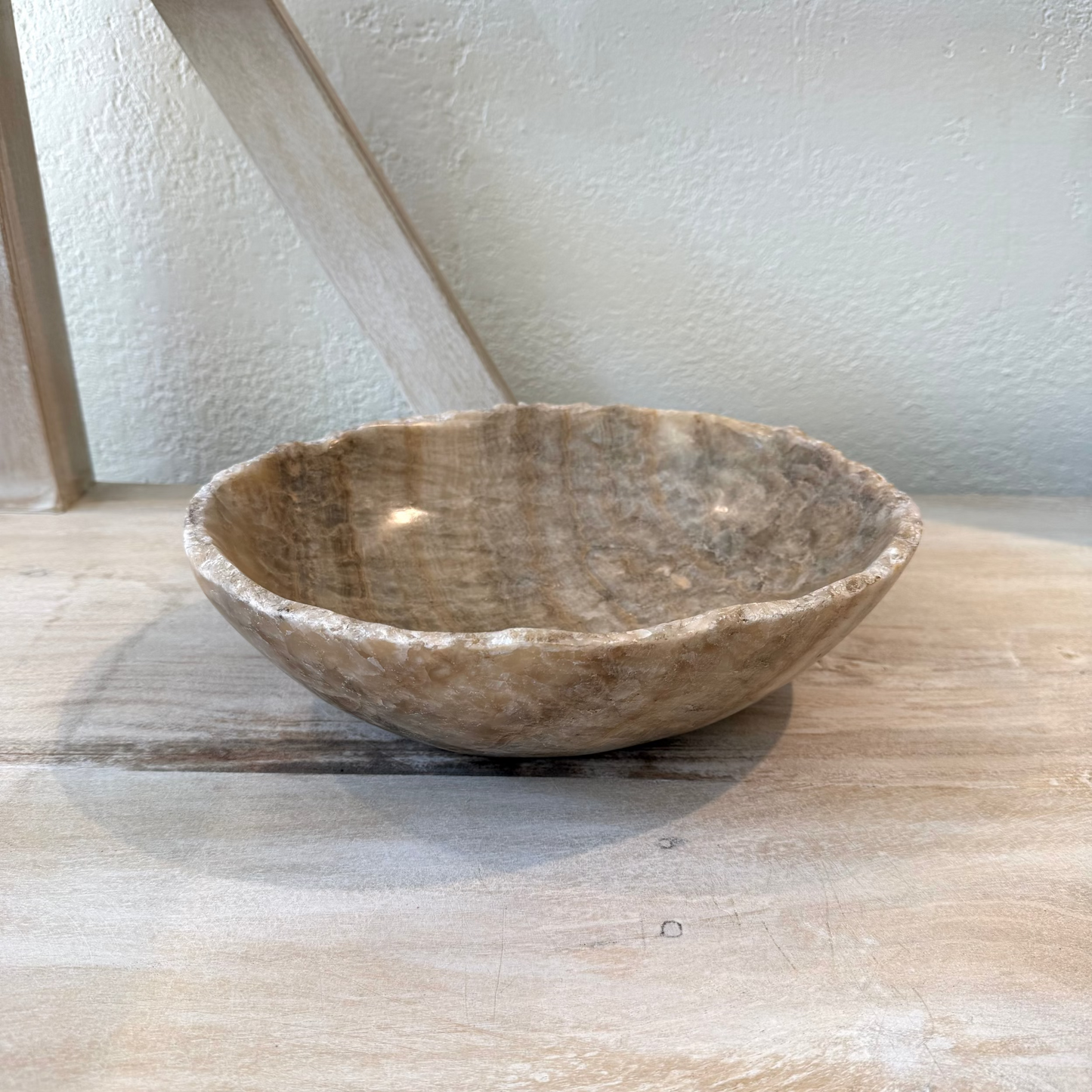 Brown stone bowl on a wooden surface with a light background