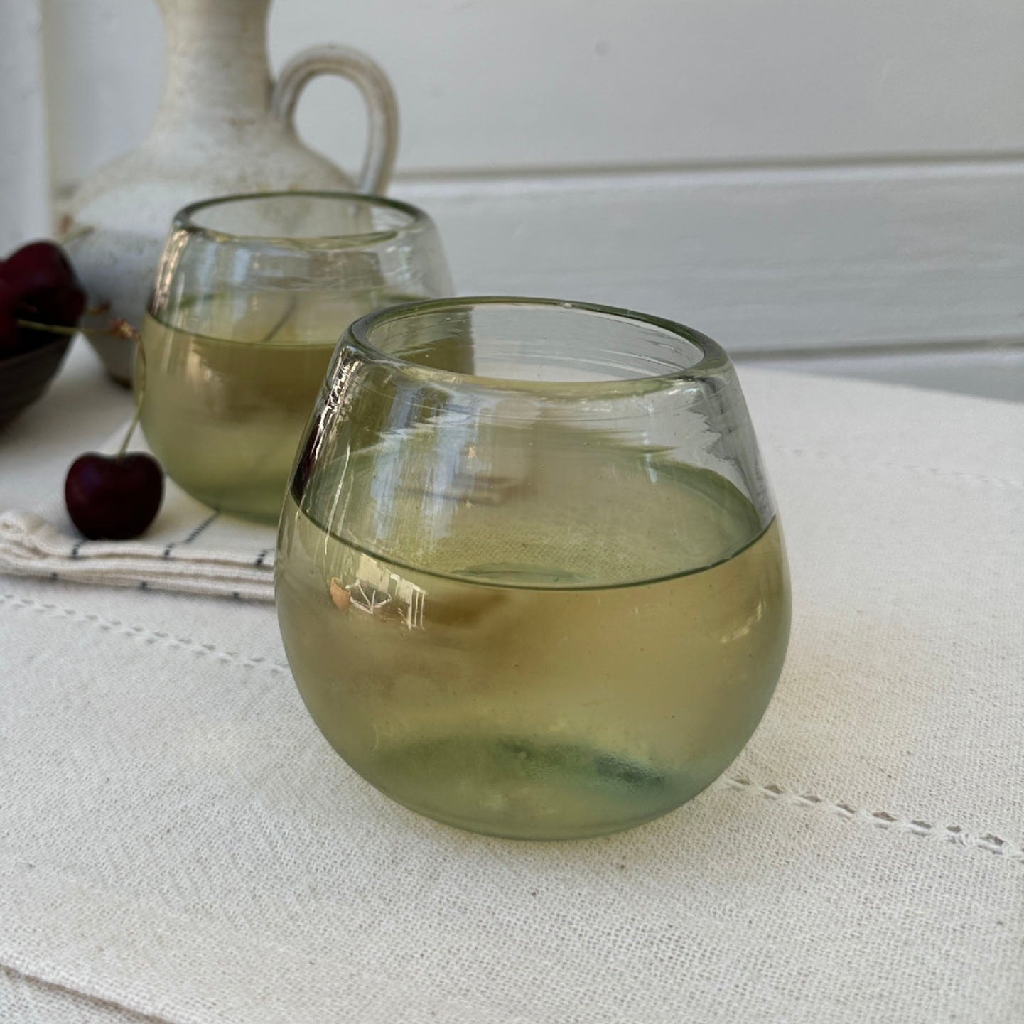 
                  
                    The stemless wine glass holding a generous amount of Sauvignon Blanc, on a table outside in Petaluma on a casually set table for an afternoon drink 
                  
                