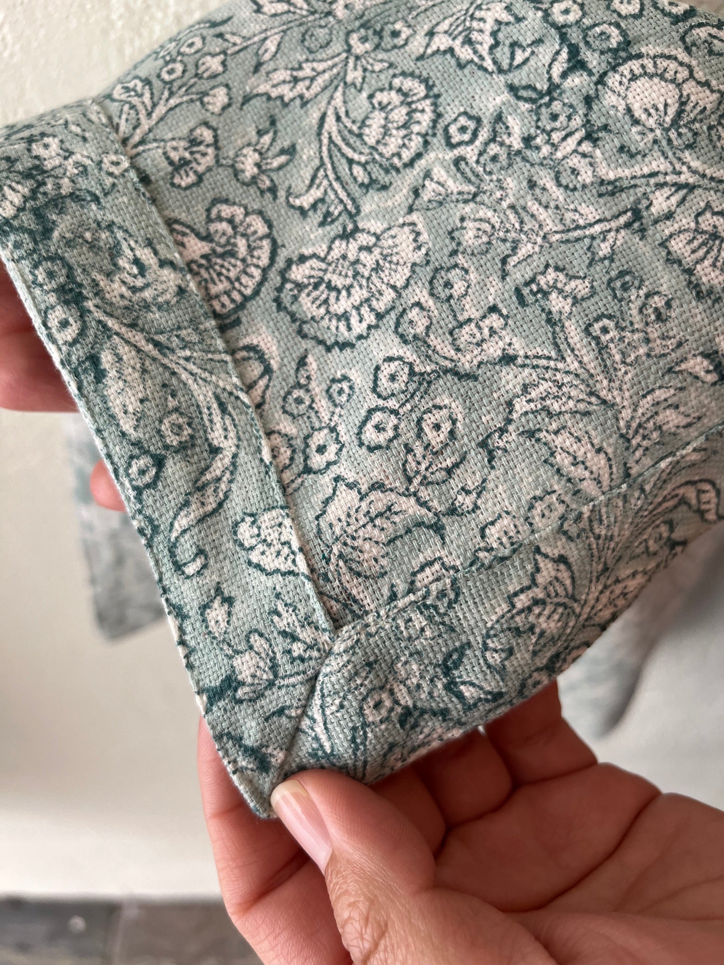 
                  
                    A close up image of a floral napkin showing the two different blue colors that make up the print
                  
                