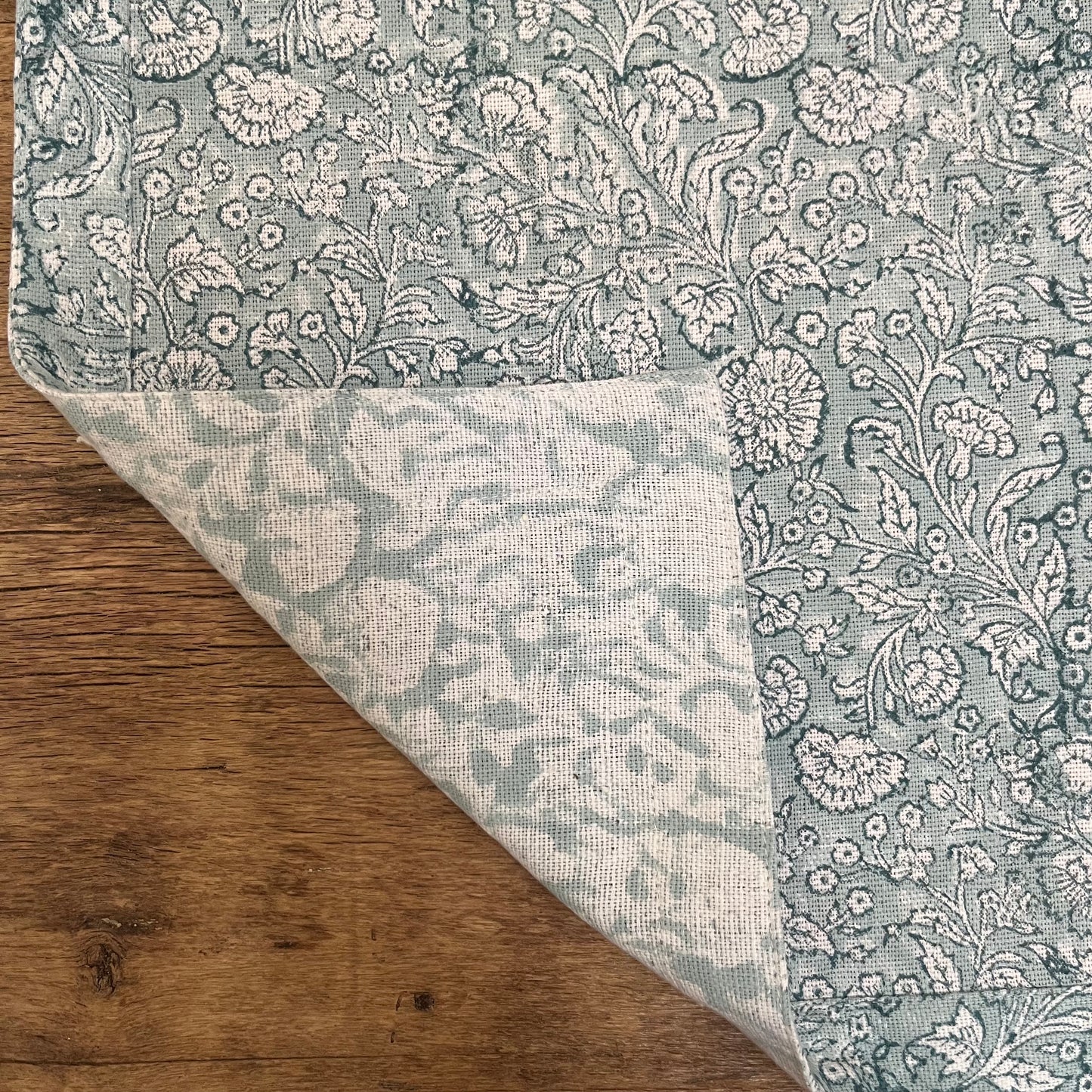 
                  
                    A napkin with the corner turned over to show the quality of the stitching on both sides
                  
                
