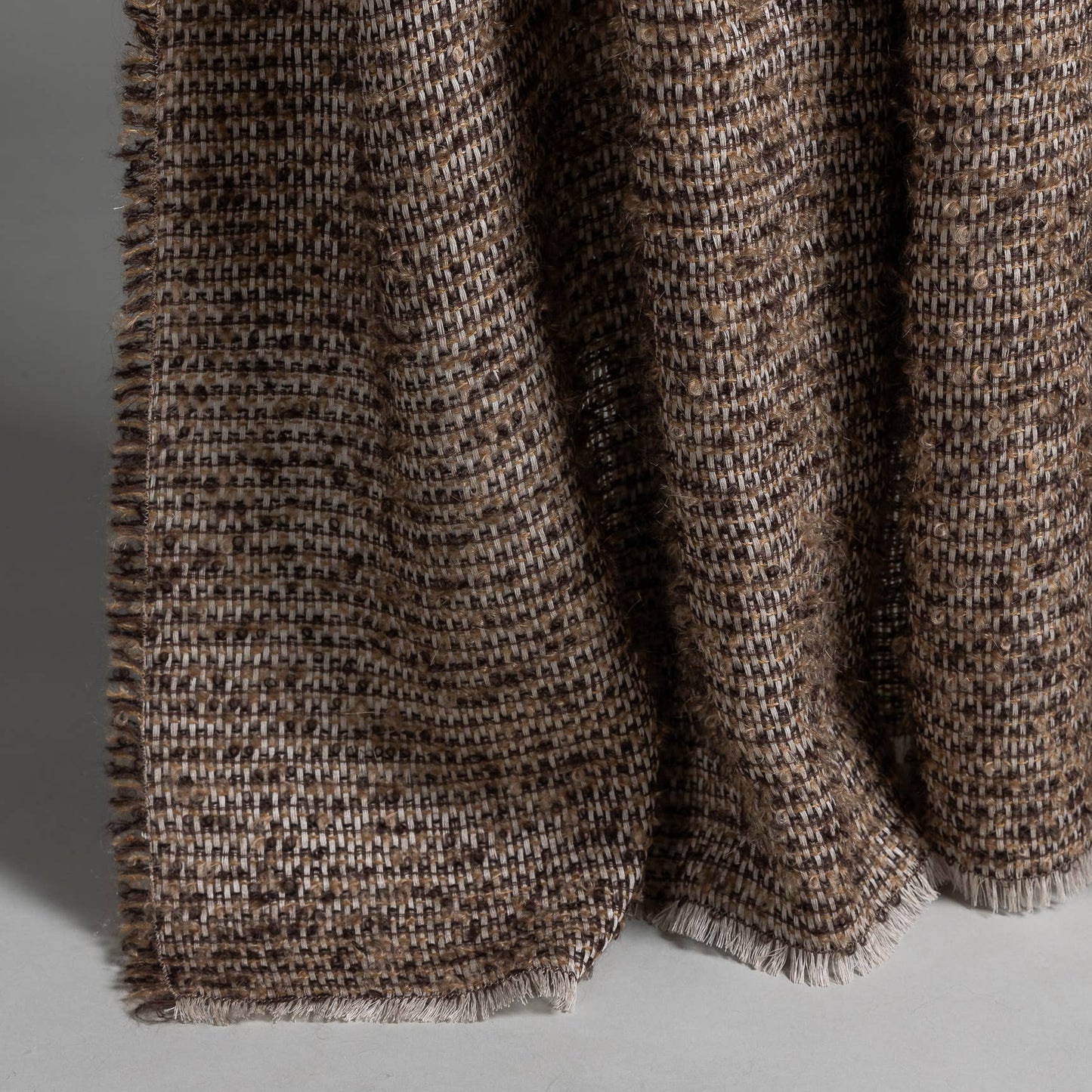 
                  
                    Textured brown fabric with a subtle pattern on a light gray background
                  
                