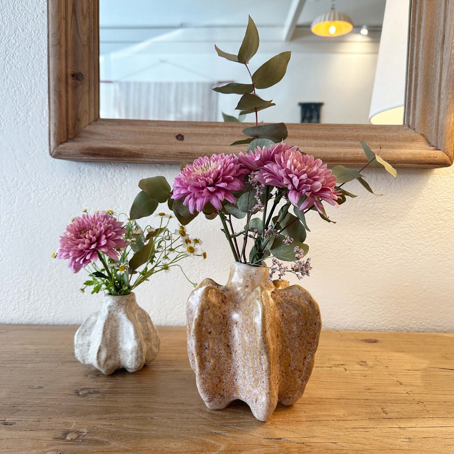Organic shaped stoneware vases with fresh flowers.