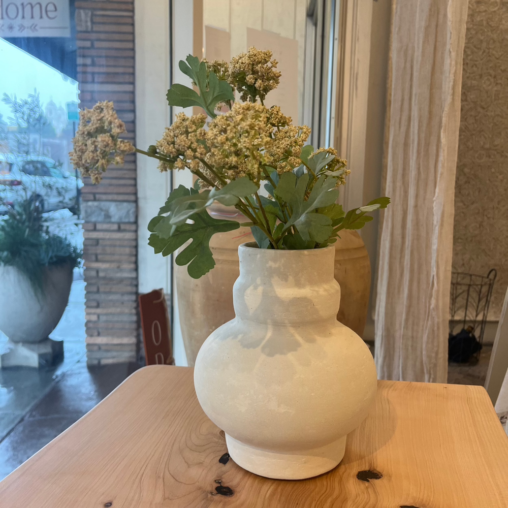 a vase stage in a store window with yellow flowers