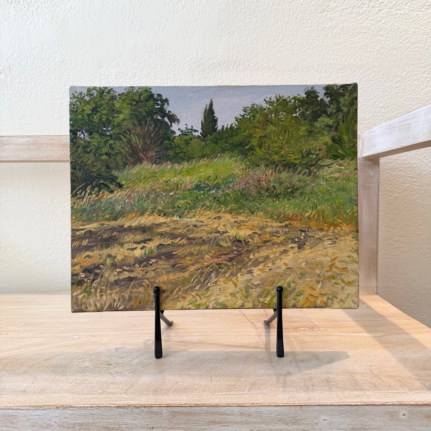 Artistic depiction of a landscape on a wall above a sink.