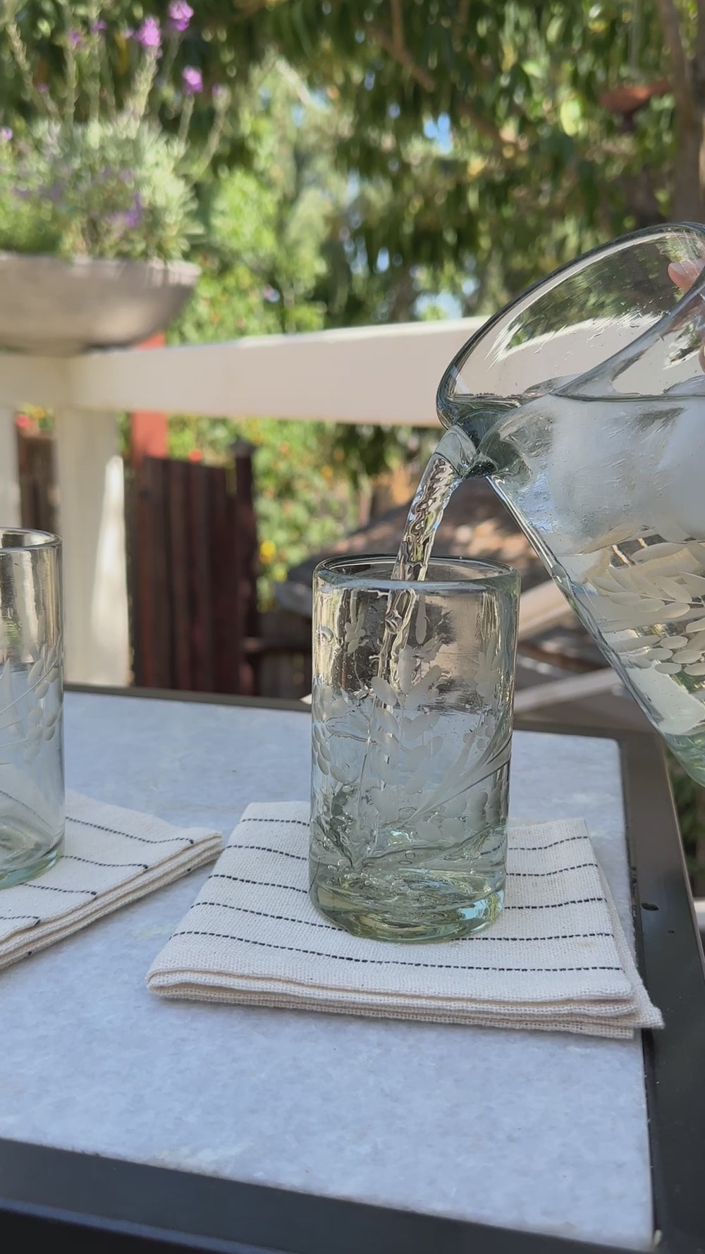 a video of water being poured from etched pitcher into etched glass