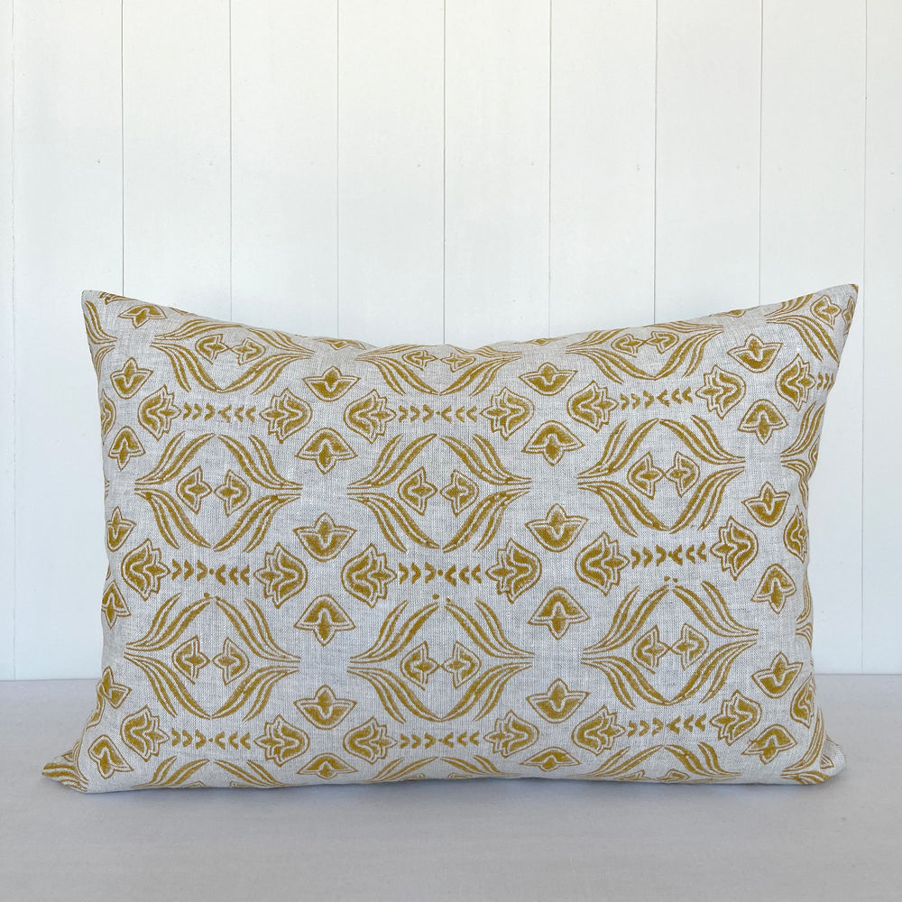 Lumbar size throw pillow featuring hand block printed floral pattern. Natural colored linen is stamped with a golden yellow pattern.